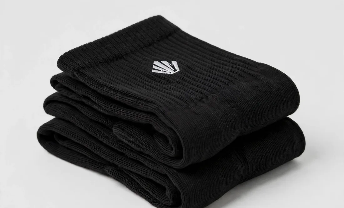 Chaussettes noires — Bord côtelé, logo tissé.