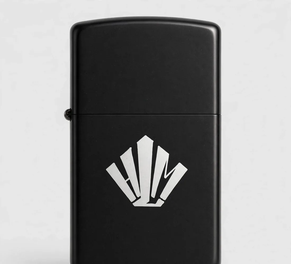 Briquet noir mat — Boîtier métal, logo HLM gravé.